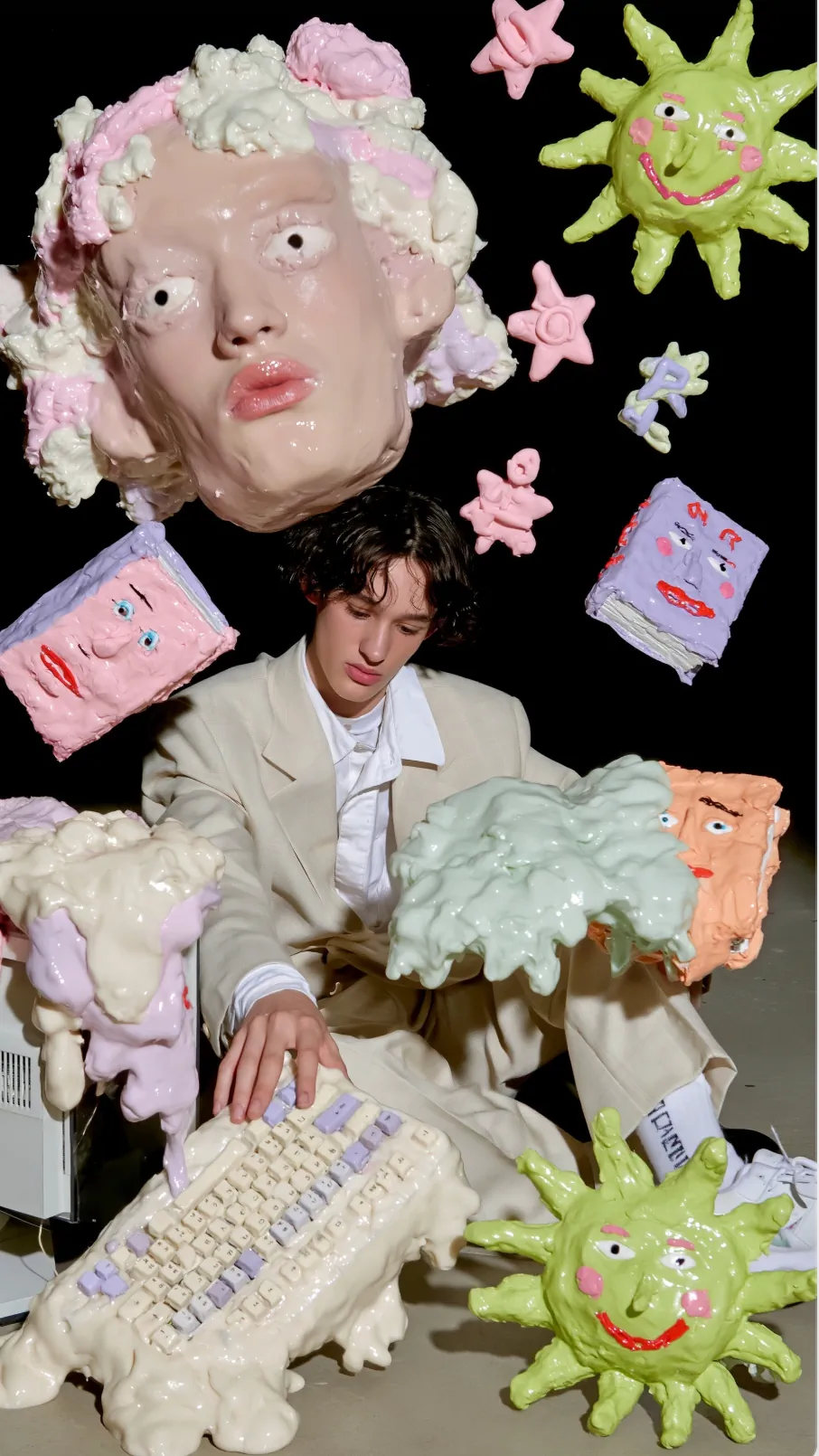 surreal editorial composition, hyperrealistic human mixed with handmade plasticine sculptures, tactile clay textures, weird art-school energy, black studio background, a creative student sitting at a computer surrounded by floating symbolic objects of knowledge and creativity, oversized sculptural head with expressive eyes, melting keyboard, strange books with faces, smiling sun with human features, abstract stars and symbols floating around, playful intellectual chaos, handcrafted clay aesthetic mixed with realistic skin and cinematic lighting, awkward poetic proportions, contemporary art installation vibe, experimental fashion editorial, soft glossy clay surfaces, highly detailed textures, stop-motion feeling, strange and intelligent atmosphere, muted pastel palette with pink, lavender, cream, pale green and peach, surrealism, mixed media sculpture, dark empty background, museum installation mood, ultra detailed, realistic shadows, art brut meets modern creativity